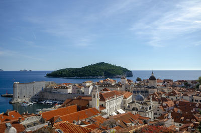 High angle view of townscape by sea against sky