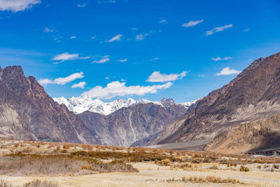 Scenic view of snowcapped mountains against blue sky