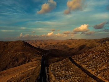 Scenic view of road amidst desert against sky