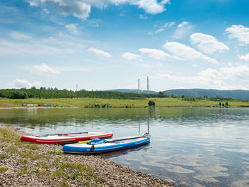 Two colors set of stand up paddleboards on a lake beach. sport and relax at milada lake, czechia.