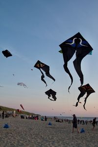 People at beach against sky