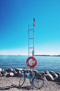 Lifeguard hut on beach against clear blue sky