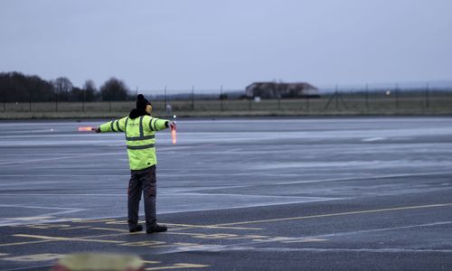 Rear view of man standing on runway