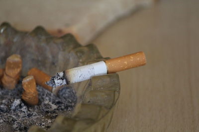 Close-up of cigarette smoking on table