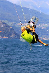 Man paragliding in sea against sky