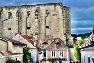 Low angle view of old building against cloudy sky