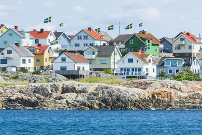 Houses along the shore bearing swedish flags