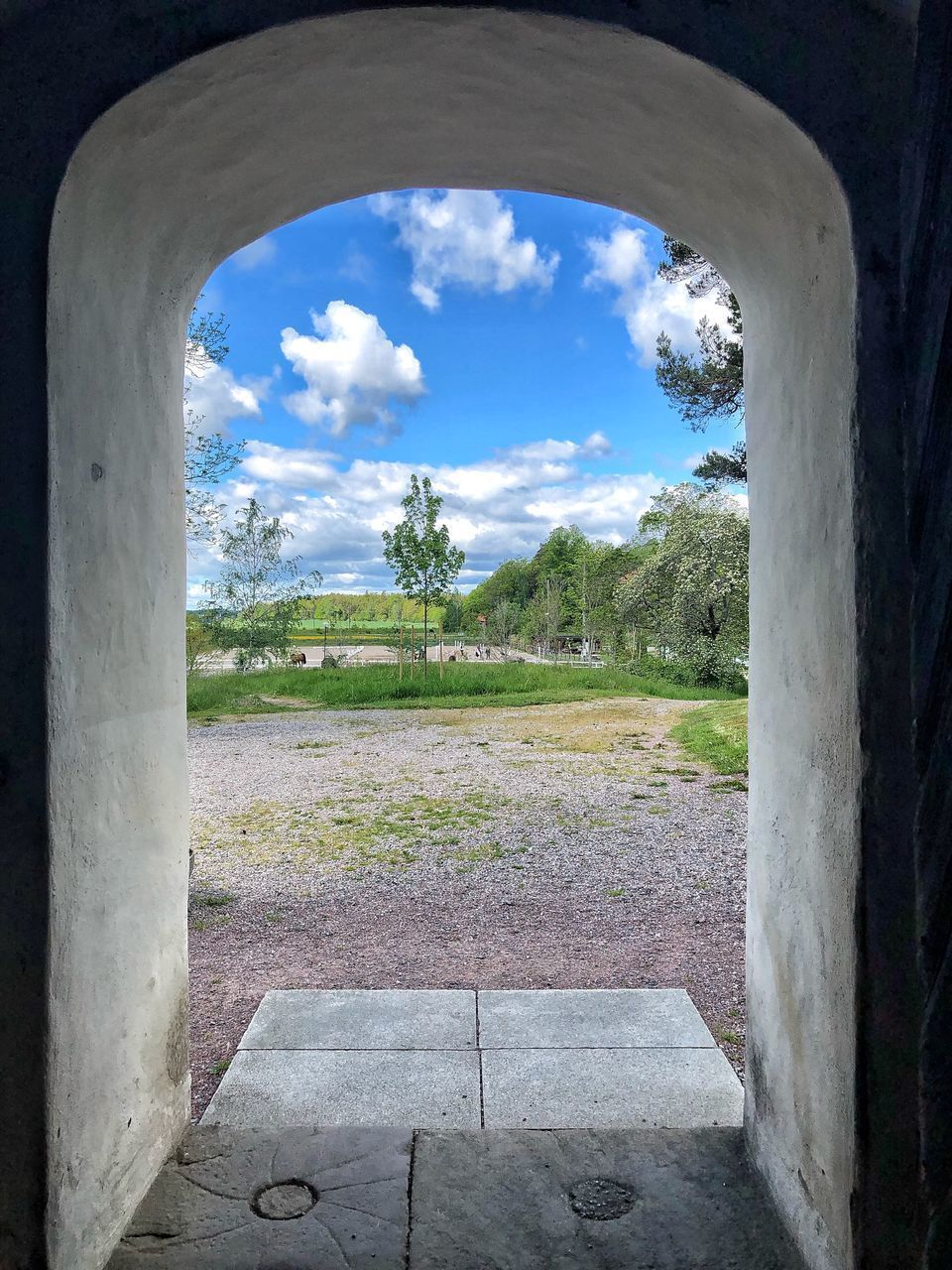 TREES ON FIELD AGAINST SKY SEEN THROUGH ARCH