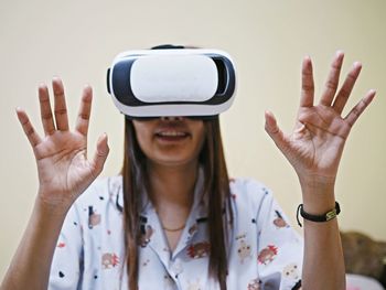 Woman gesturing while using virtual reality simulator