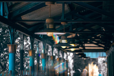 Low angle view of illuminated lights hanging on ceiling in building