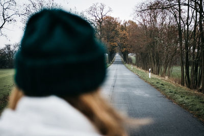Rear view of man on road amidst trees