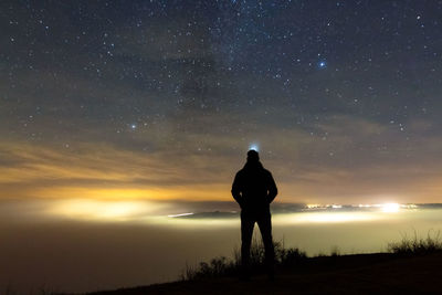 Full length of man with umbrella against sky at night