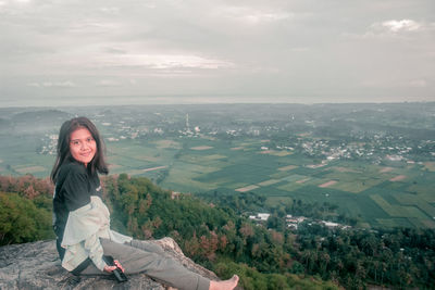 Portrait of woman standing on mountain against sky