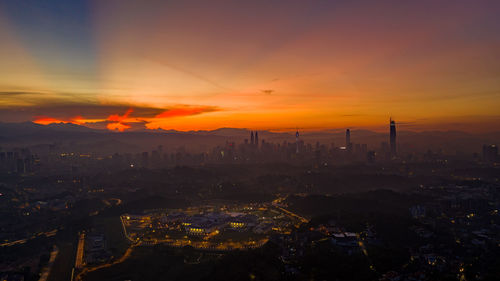 Aerial view of illuminated cityscape against sky at night