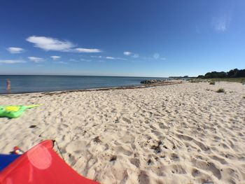 Scenic view of sandy beach against blue sky