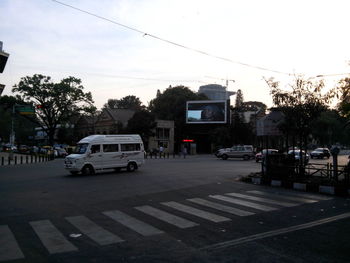 Cars on city street against sky