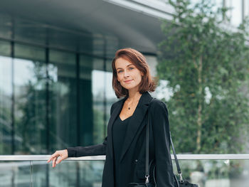 Portrait of young woman standing in city