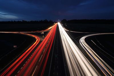 High angle view of light trails on highway at night