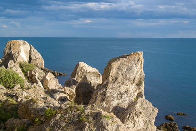 Rock formations by sea against sky