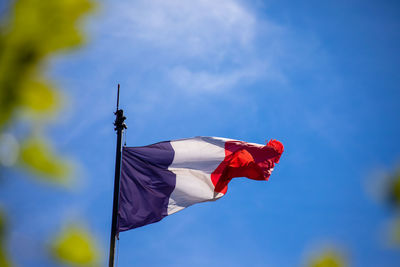 Low angle view of flag against blue sky