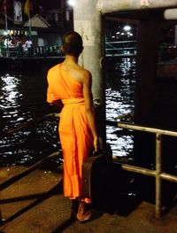 Full length of young woman standing by railing