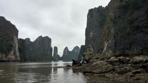 Rock formations by sea against sky