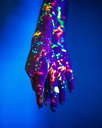 Close-up of illuminated lighting equipment against blue background