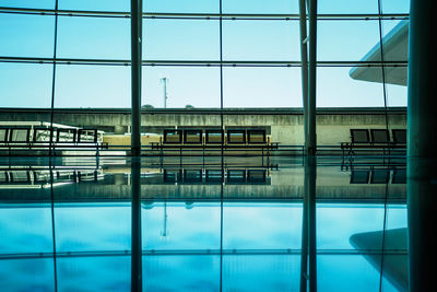 Empty seats by glass window at airport