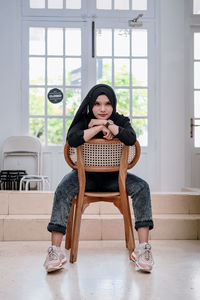 Portrait of young woman sitting on floor