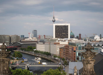 Buildings in city against cloudy sky