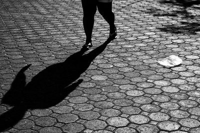 Low section of women walking on cobblestone footpath