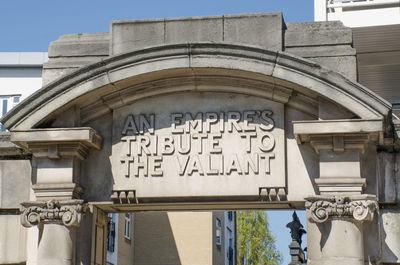 Low angle view of text on building against sky