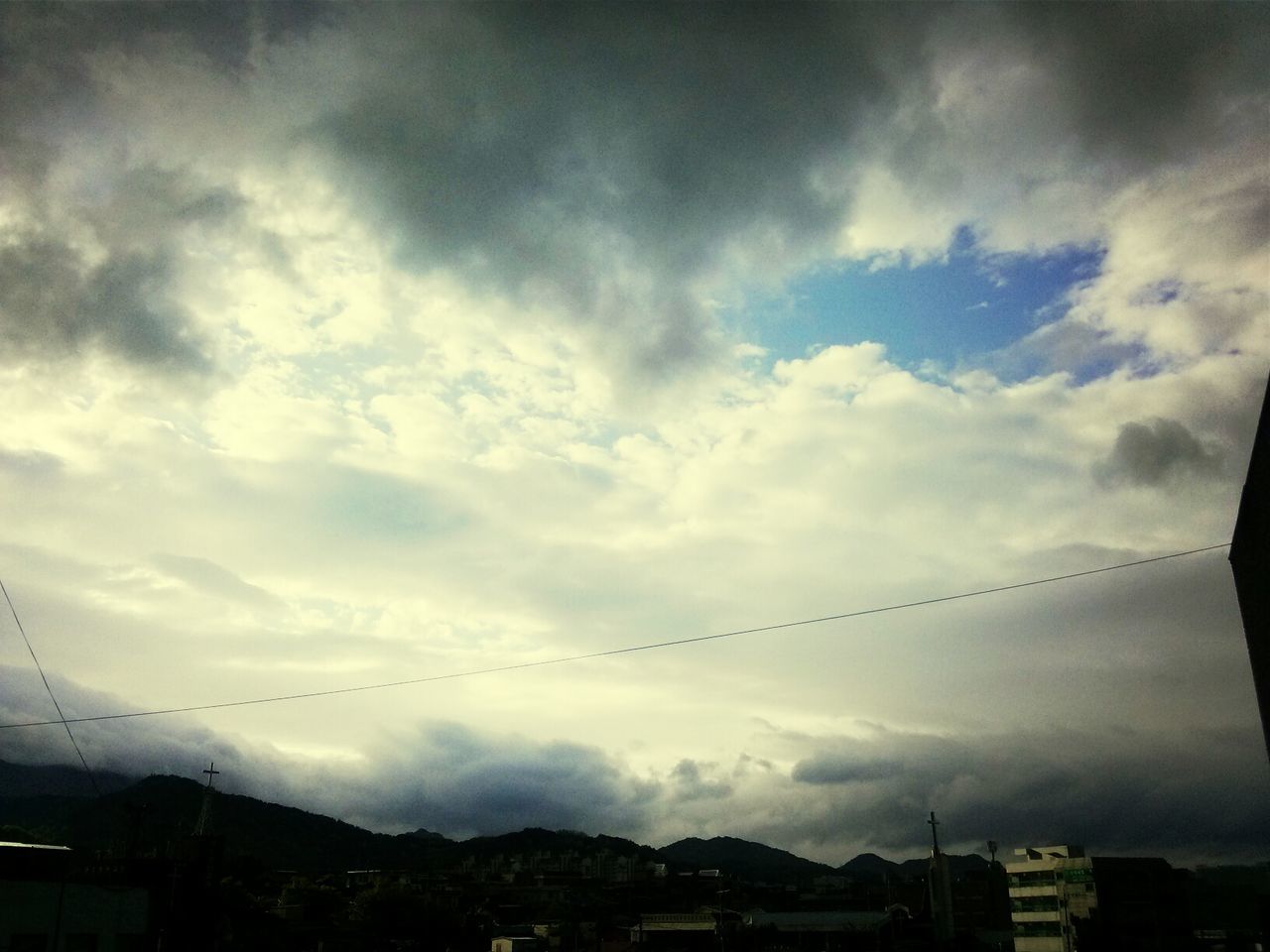 sky, cloud - sky, mountain, power line, electricity pylon, built structure, cloudy, electricity, building exterior, architecture, cable, weather, nature, connection, landscape, mountain range, beauty in nature, scenics, cloud, power supply