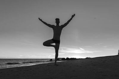 Full length of man exercising at beach