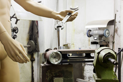 Cropped hands of man repairing machine