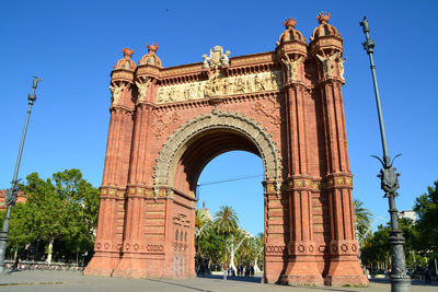 Low angle view of triumphal arch against clear blue sky