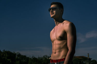 Midsection of man with arms raised against clear sky