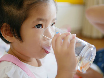 Close-up of girl drinking juice in glass