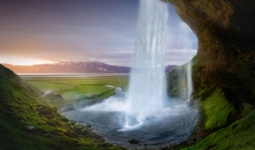 Scenic view of waterfall against sky