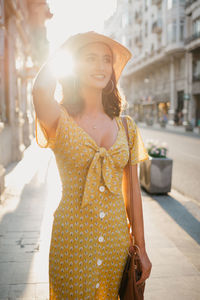 Side view of young woman standing in city