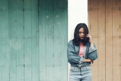 Portrait of woman standing against wall