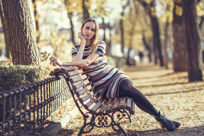 Portrait of smiling young woman sitting in park