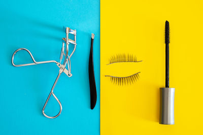 High angle view of eye make-up equipment on colored background