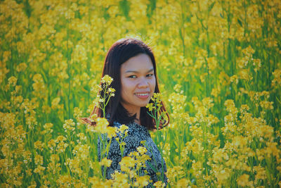 Portrait of smiling young woman standing on field