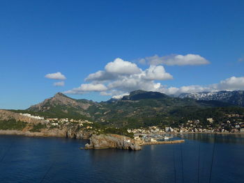 Scenic view of sea by mountains against sky porto soller, mjorca