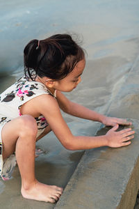 Side view of woman sitting in swimming pool