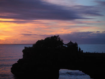 Scenic view of sea against dramatic sky during sunset