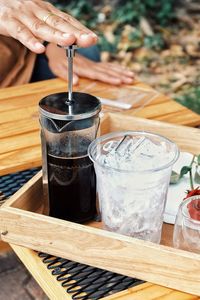 Close-up of hand holding drink on table