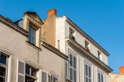 Low angle view of old building against clear blue sky