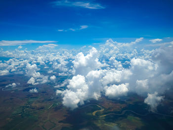 Aerial view of clouds over landscape against blue sky